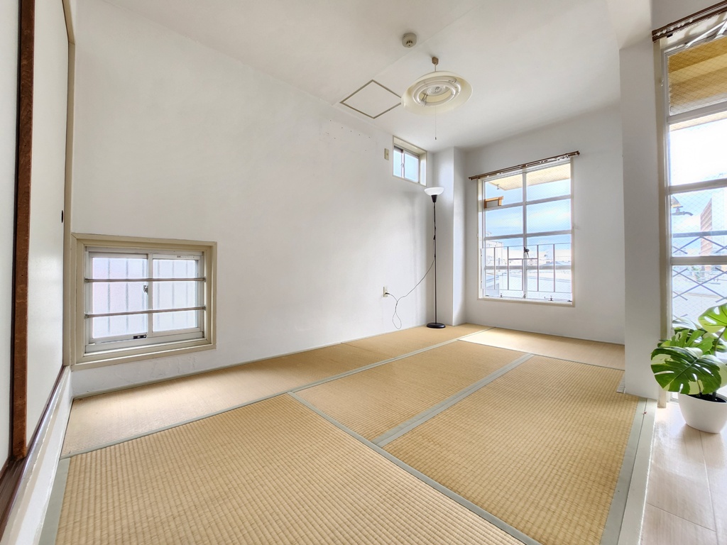 アパルトマンKの南向き6帖和室は角部屋の為、南側と東側に窓がついている。太陽光が塩塗りの壁を照らし、心地よい風が吹き込んでいる。